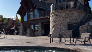 A large stone building with a pool and outdoor seating.