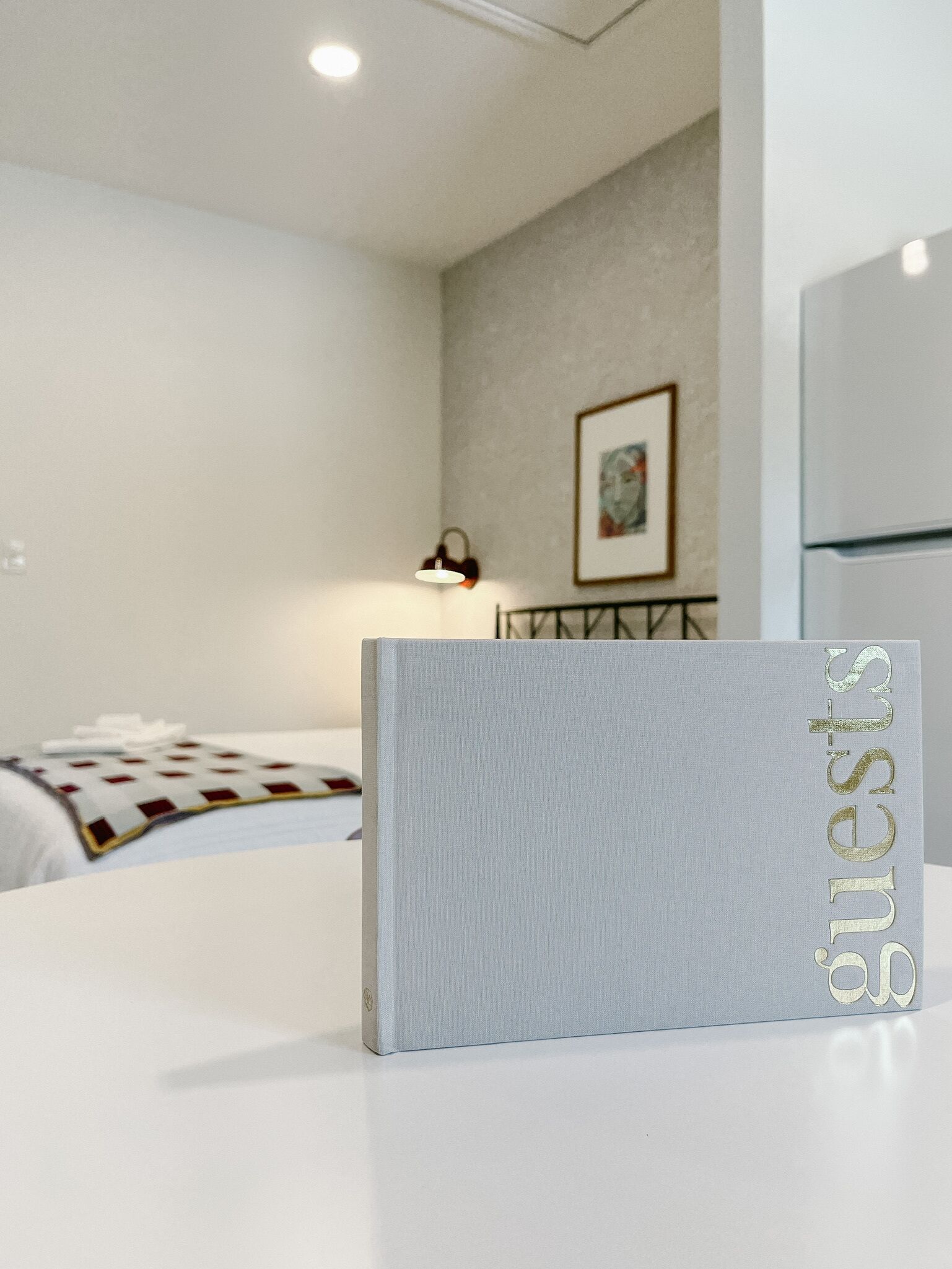 Una camera d'albergo con un letto, un comodino, una lampada e un quadro appeso al muro.