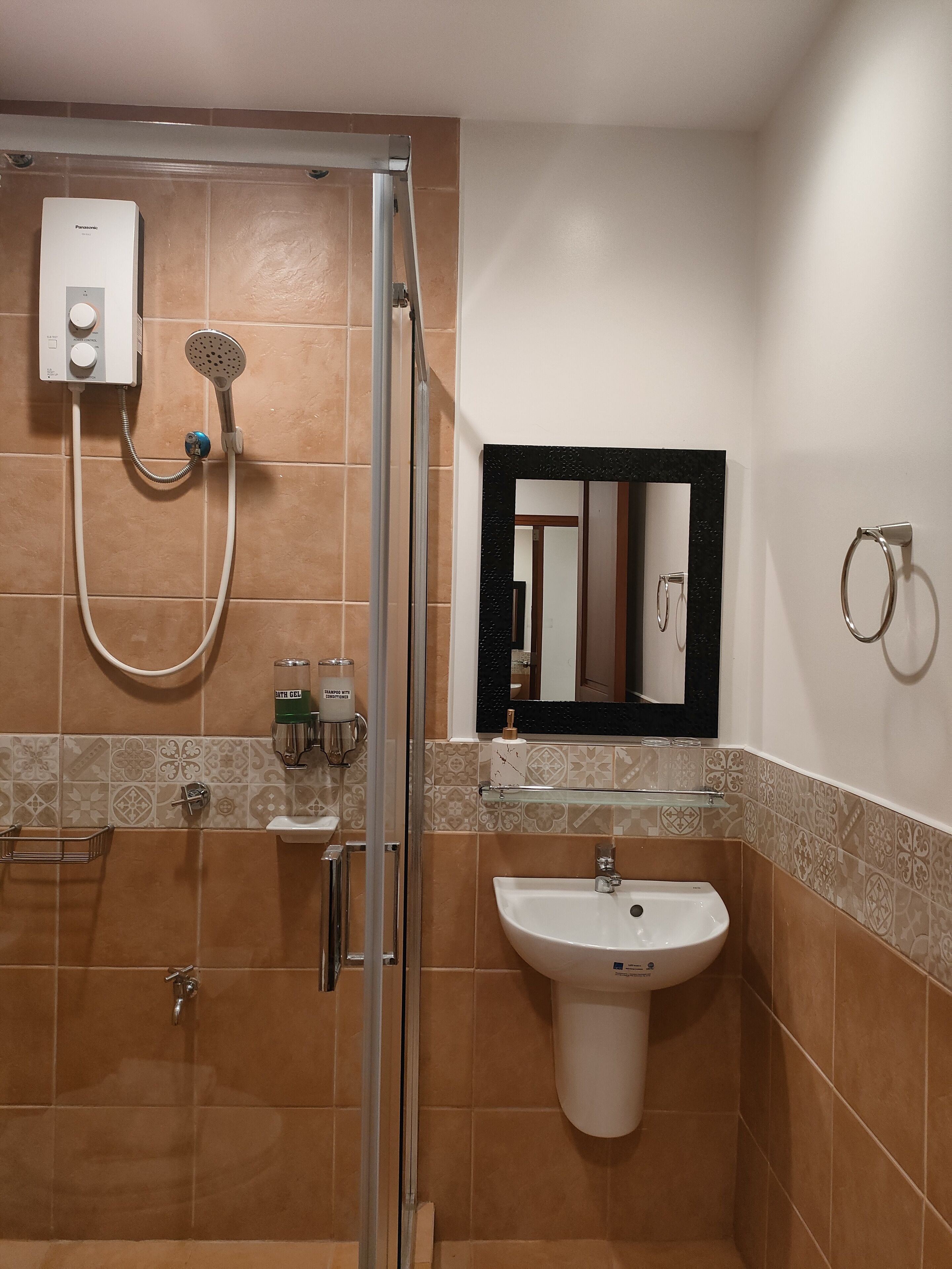 A bathroom with a shower, a sink, and a mirror.