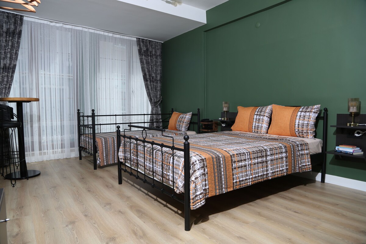 Ein Zimmer mit zwei Betten, einem Schreibtisch und einem Stuhl.
