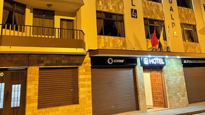 Um hotel com fachada moderna, várias varandas e uma placa chamativa indicando que se trata de um hotel.