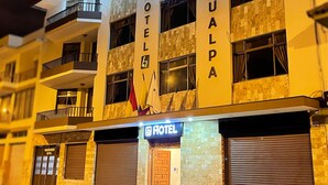 Um hotel com uma placa indicando "HOTEL AHALPDA" e uma entrada visível com um toldo fechado.