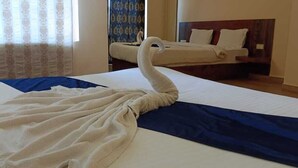 A hotel room with two beds, one with a swan-shaped towel on the bedspread. - Hotel Sagar Tarang (Berries Group) (Puri)