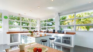 A modern kitchen with large windows, stainless steel appliances, and a granite countertop. - Secluded Paradise Your Exclusive Villa  (Rawai)