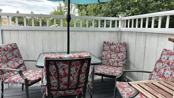 A patio with a table and four chairs, each with a floral pattern.