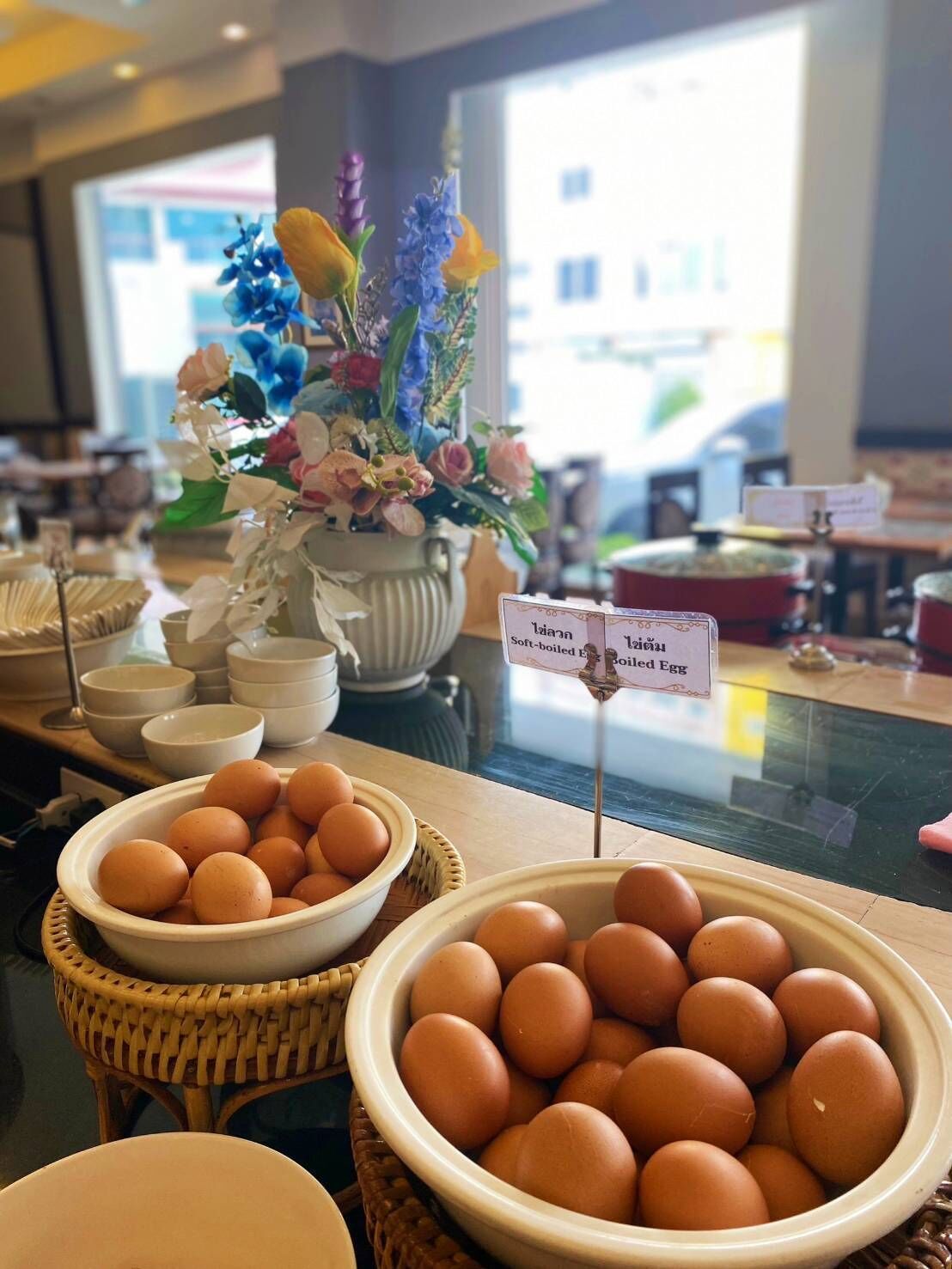 A buffet area with bowls of eggs and a sign indicating soft-boiled eggs.