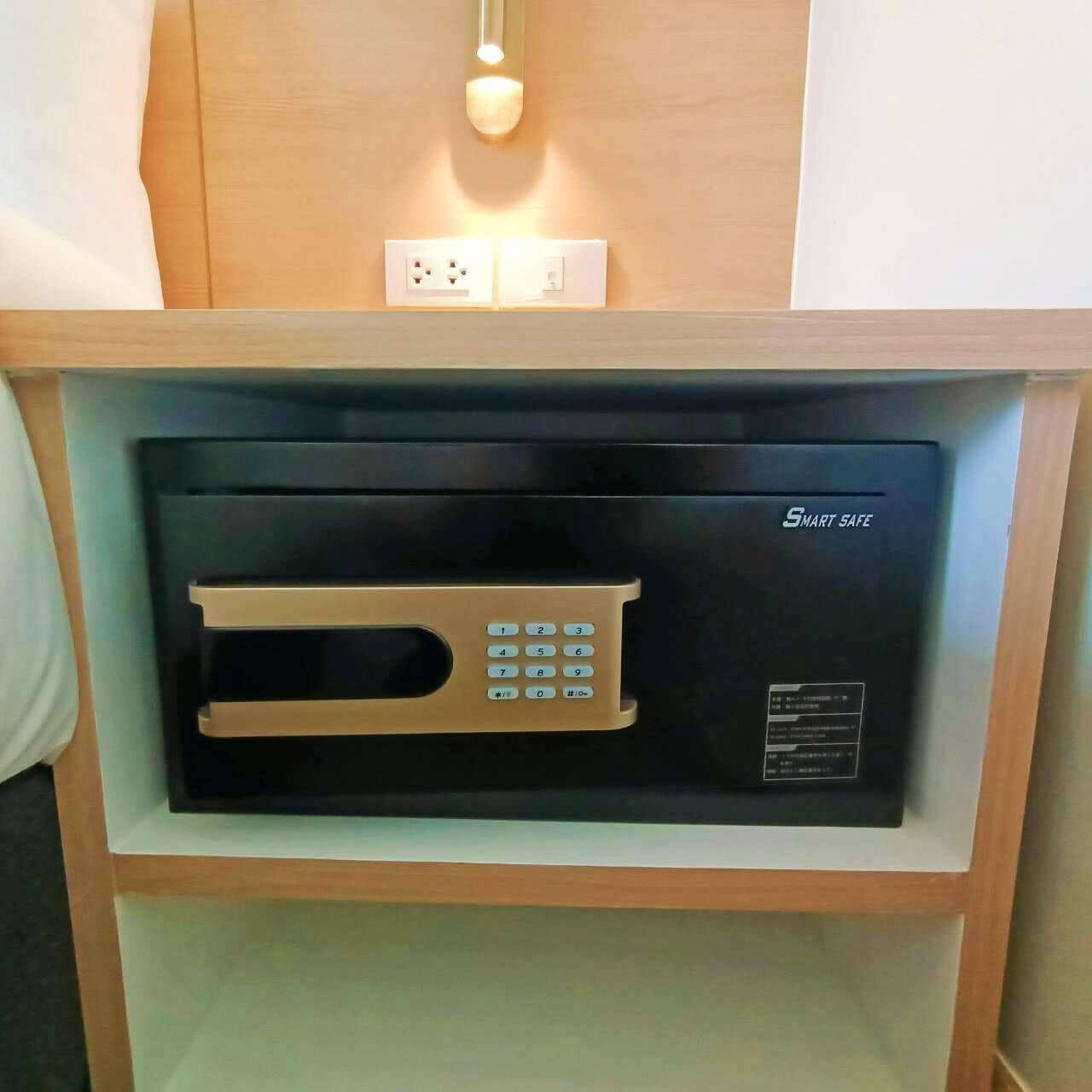 A black security intercom with a keypad and a light above it, mounted on a wooden shelf.
