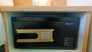 A black security intercom with a keypad and a light above it, mounted on a wooden shelf.