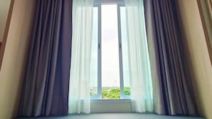 Una habitación con un ventanal grande, un banco acolchado y una lámpara de techo.
