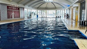 An indoor swimming pool with a high ceiling and large windows. - Chevron Renaissance-Resort Style Living managed by Gold Coast Premium (Surfers Paradise)