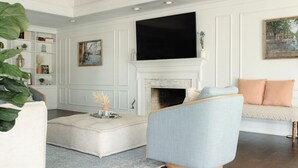 A living room with a fireplace, a television, and a bookshelf. - The Fairway to Heaven (Bryan)