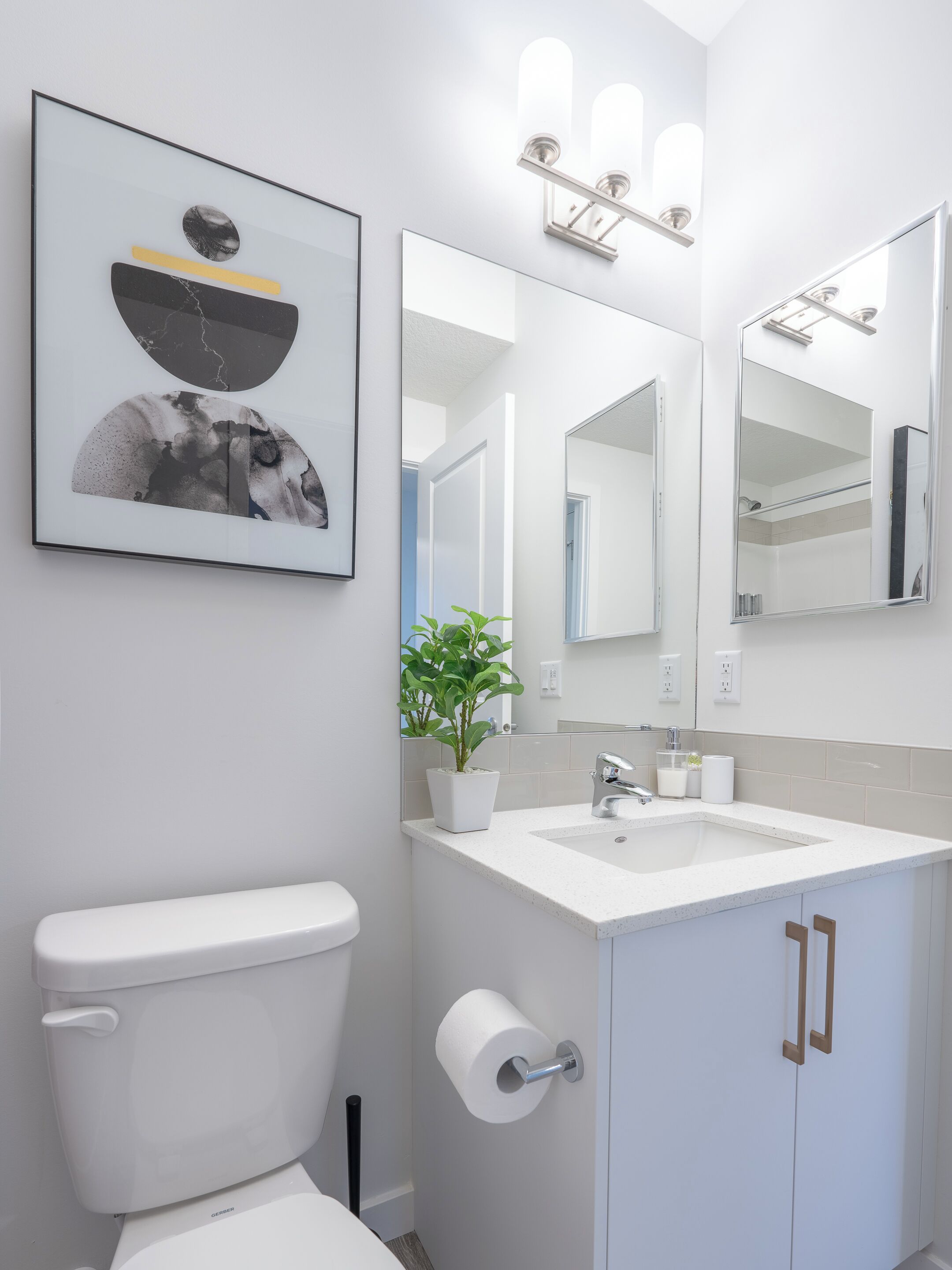 Un baño moderno con inodoro, lavabo y espejos.