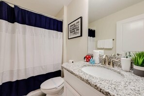 Bathtub, hair dryer, towels, shampoo