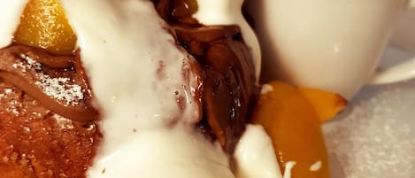 A dessert plate with chocolate-covered pastries, a scoop of ice cream, and slices of peach.