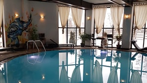 An indoor swimming pool with clear glass walls, a mural of a sea creature, and a view of the outside. - Casa Drumeţului (Savinesti)