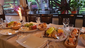 A dining table set with plates of food, glasses, and cutlery. - Casa Drumeţului (Savinesti)