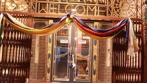 A traditional gate with intricate carvings and a sign that reads "WELCOME". - Hotel De Purang (Muktinath)