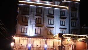 A hotel with multiple floors, balconies, and a sign indicating it is a hotel. - Hotel De Purang (Muktinath)