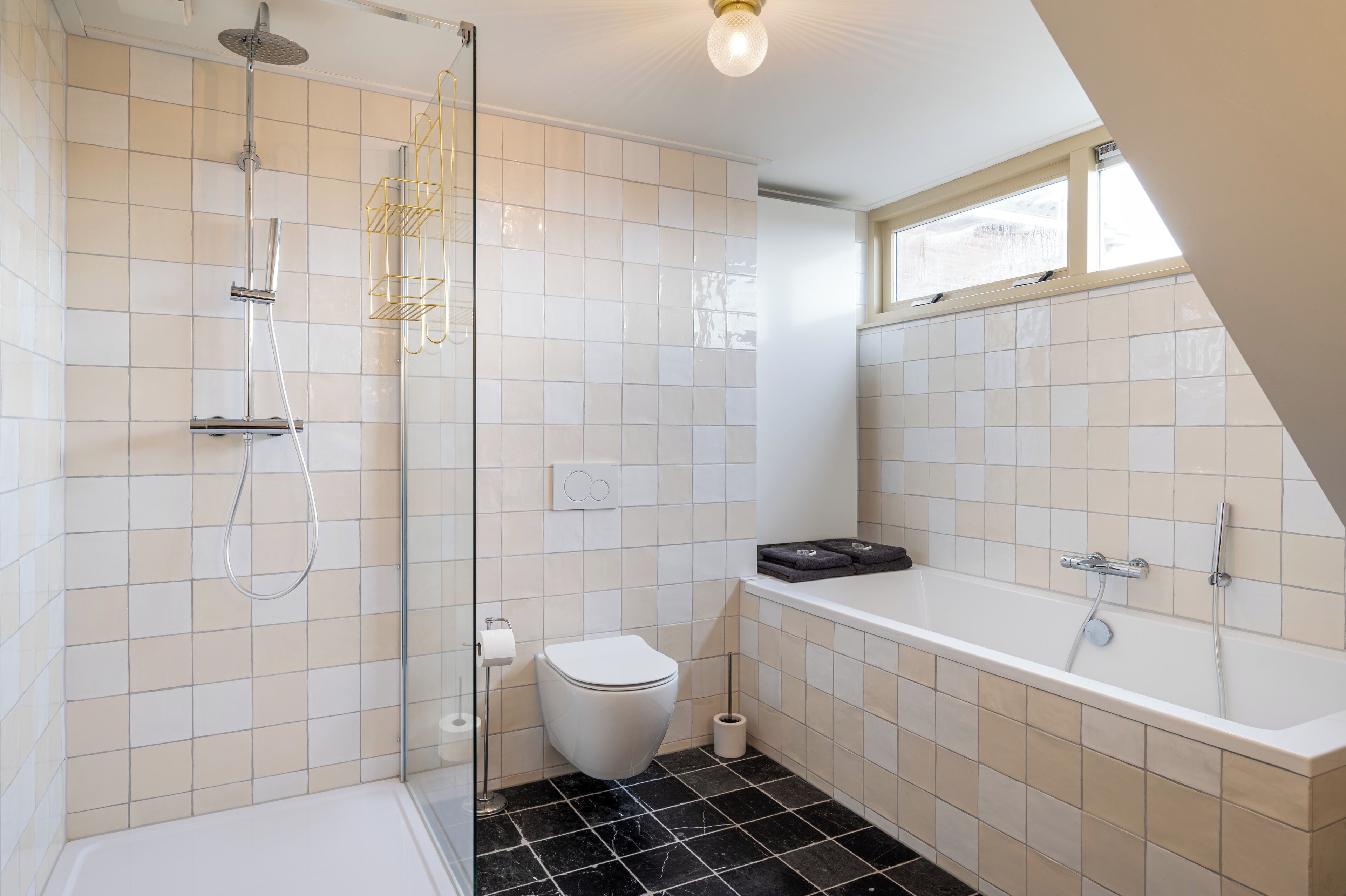 Une salle de bain moderne équipée d’une douche, de toilettes et d’une baignoire.