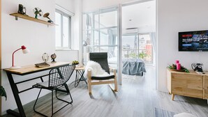 Un salon moderne avec un bureau, une chaise et une grande fenêtre.