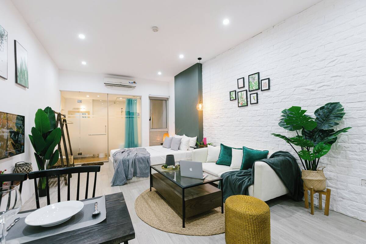 A modern living room with a sofa, coffee table, and dining area.