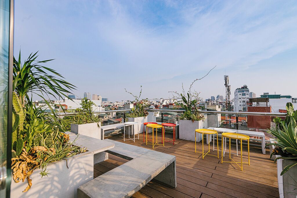 Une terrasse sur le toit, dotée d’un espace extérieur aménagé et de plantes en pot.