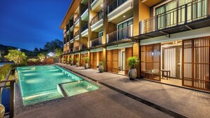 Un hotel con piscina, varios balcones y un diseño arquitectónico asiático tradicional.