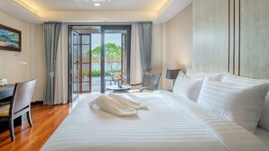 Habitación de hotel con una cama grande, un escritorio, una silla y vistas al exterior a través de un ventanal.