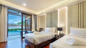 Habitación de hotel con dos camas, una mesita con lámpara y vistas a una piscina.