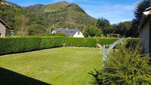 A grassy yard with a white house and a mountain in the background. - Maison de Montagne Avec Jardin Privé (Sarrancolin)