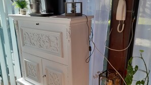 A white cabinet with decorative carvings, a lamp, and a telephone on a tiled floor. - Maison de Montagne Avec Jardin Privé (Sarrancolin)