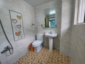 A bathroom with a toilet, sink, and shower. - e cozy Hotel (Ulleung)
