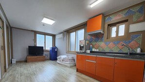 Una cocina moderna con armarios naranja, horno empotrado y salpicadero de azulejos.