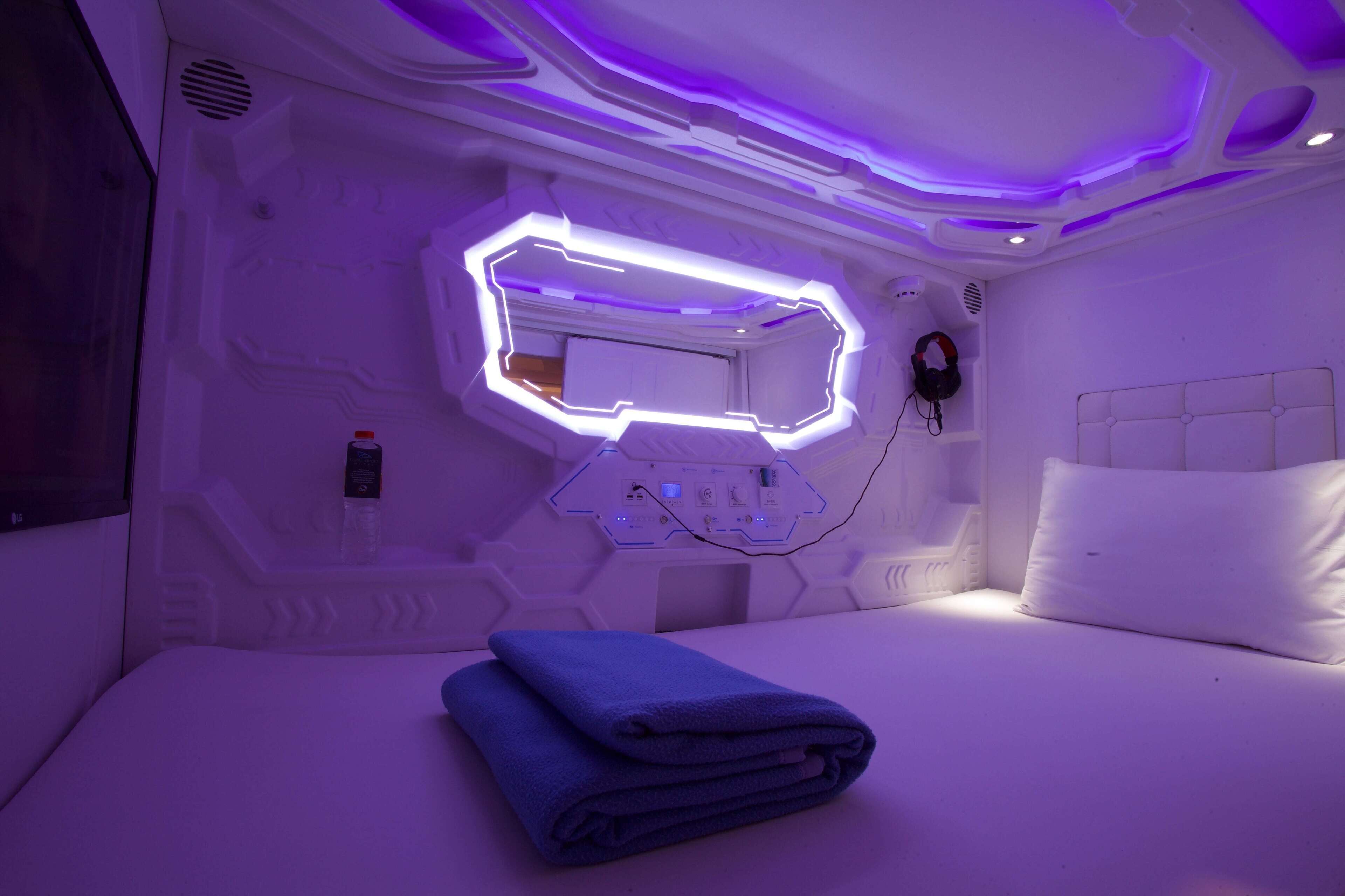 Ein modernes Schlafzimmer mit geometrischem Wanddesign, einem eingebauten Spiegel und einem ordentlich bezogenen Bett.
