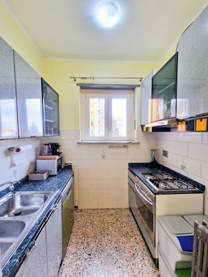 A compact kitchen with a gas stove, a microwave, and a sink.