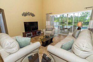 A living room with a TV, sofa, and coffee table. - 4 BEDROOMS - 3 BATHROOMS - PRIVATE POOL & SPA (Davenport)