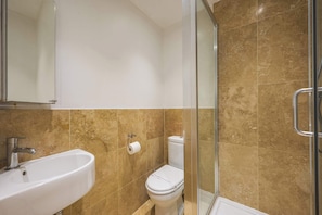 Bathroom features a sink, toilet, and glass shower enclosure.