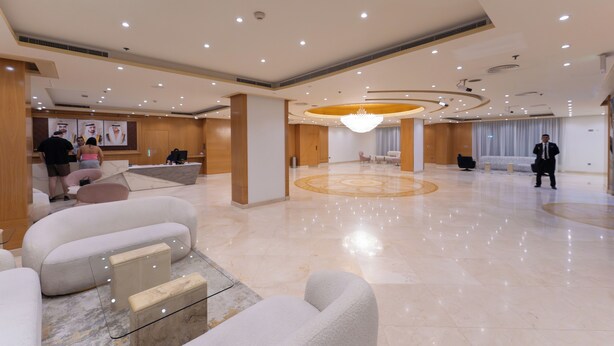 Um amplo hall de entrada com balcão de recepção, áreas de estar e um candelabro.