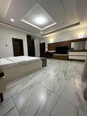 A modern living room with a sofa, a TV, and a desk area.