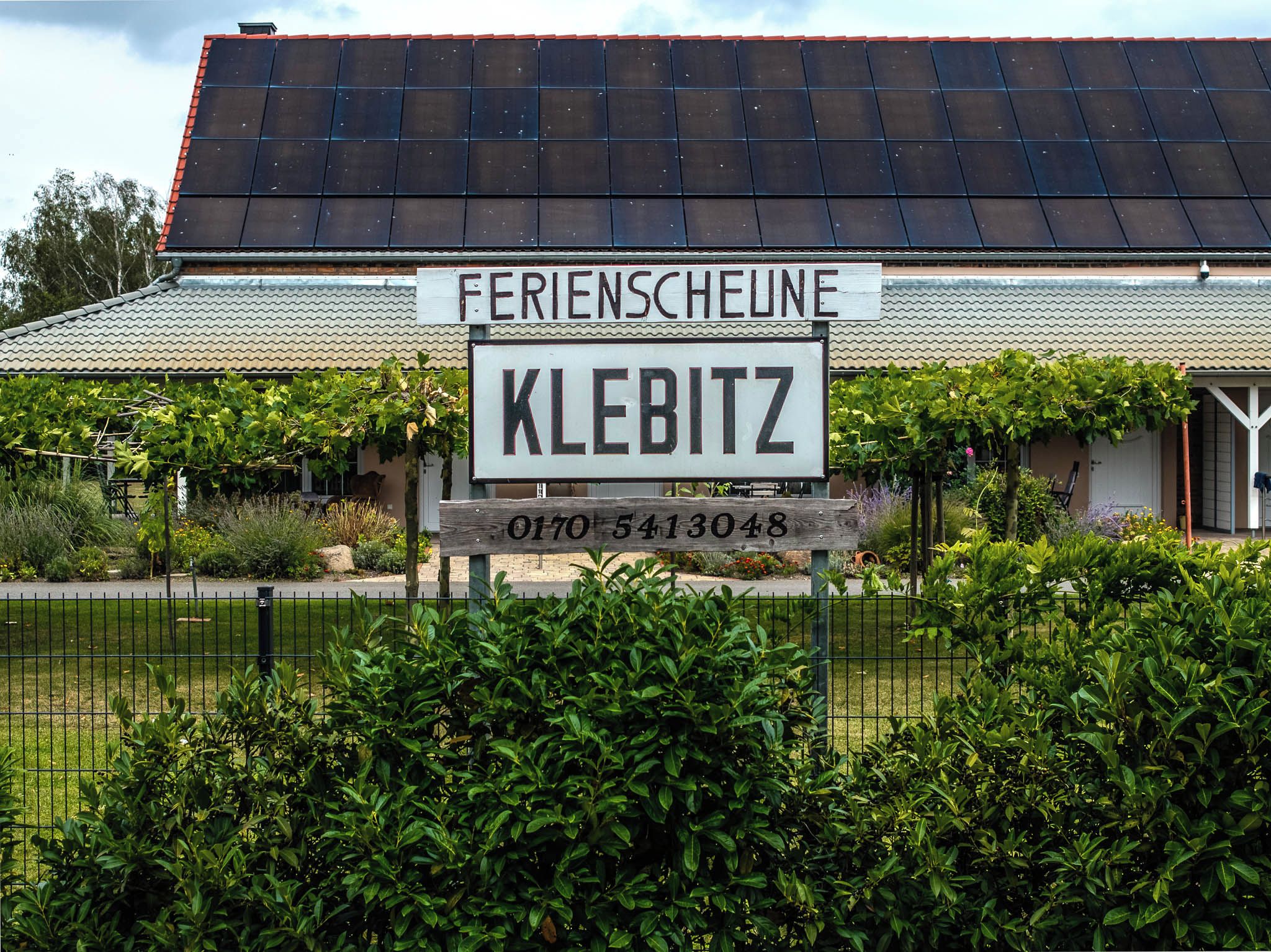 Un bâtiment avec une enseigne indiquant « Ferienscheune KLEBITZ » et un numéro de téléphone.