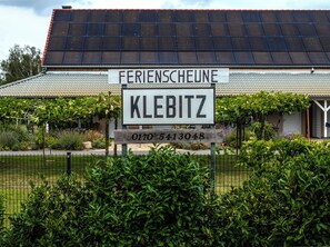 A building with a sign that reads 'Ferienscheune KLEBITZ' and a phone number. - Disabled-friendly apartment "Lena" with care bed (Zahna-Elster)