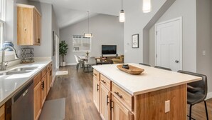A modern kitchen with wooden cabinets, a large island, and pendant lighting. - New Build, Pet Friendly, A/C, 5 Minutes to Downtown Durango (Durango)