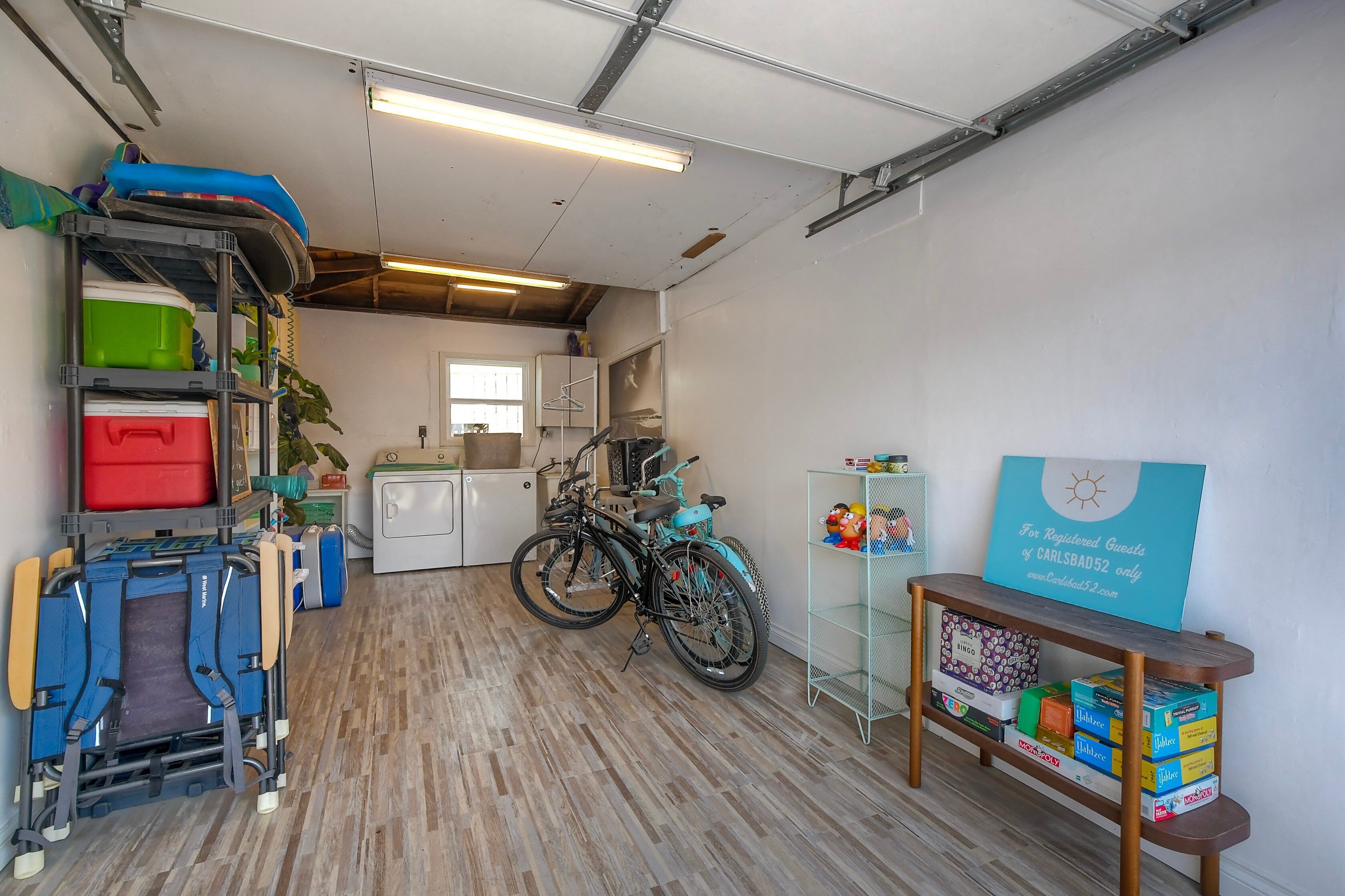 A garage with bicycles, storage shelves, and a sign for registered guests.