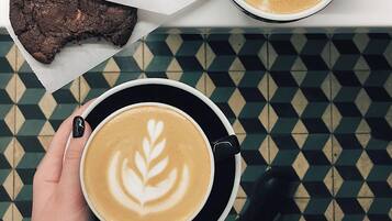 A top-down view of a table with a coffee cup, a chocolate brownie, and a decorative string.