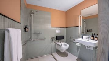 A bathroom with a toilet, sink, and shower.
