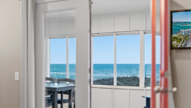 A room with a view of the ocean through large windows.