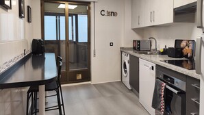 Una cocina moderna con comedor, lavadora y horno empotrado.