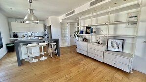 A modern kitchen with a central island, bar stools, and a built-in wine rack. - Beautiful 2BR In Ramat Gan (Ramat Gan)
