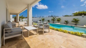 Eine moderne Außenpatio mit Pool, Sitzgelegenheit und Blick auf die umliegende Landschaft.