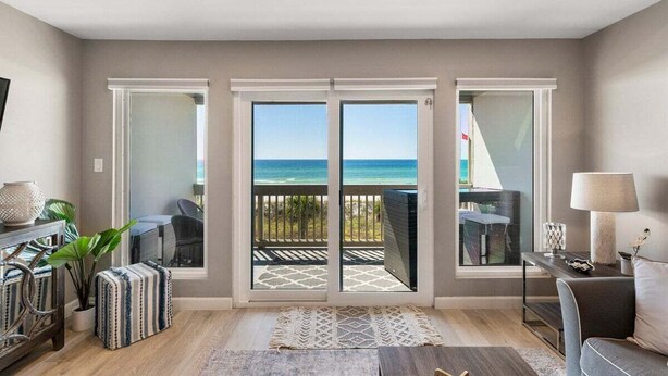 Una habitación con vista al océano, un balcón con mobiliario exterior y un diseño interior moderno.